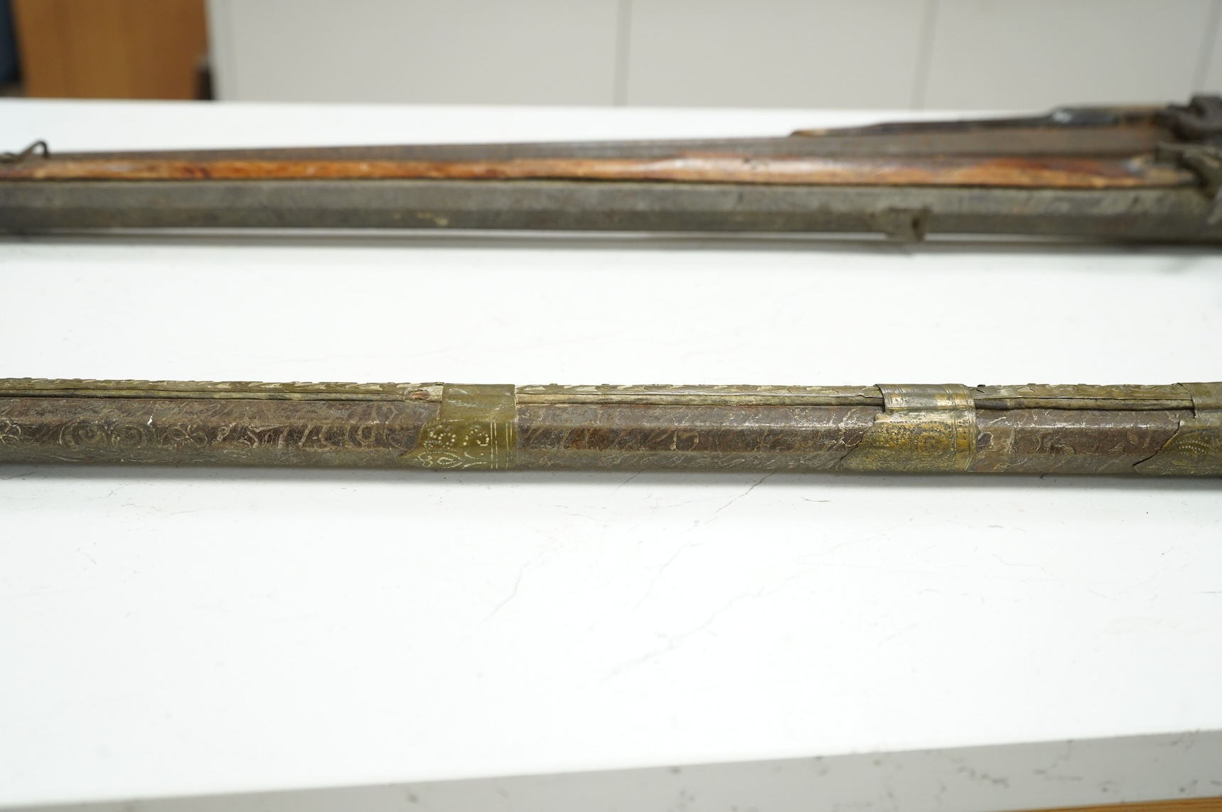 A Balkan miquelet flintlock gun with part octagonal Damascus twist barrel, silver inlaid at breach and muzzle, brass covered stock with shaped mother-of-pearl segments covering the butt, the side of stock inscribed ‘Piet